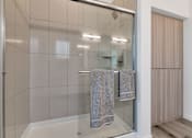 Thumbnail 20 of 35 - A bathroom with a glass shower door and a towel hanging on the side.at Marketside Villas at Verrado, Buckeye, 85396