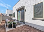 Thumbnail 25 of 35 - A white house with a patio and a chair.at Marketside Villas at Verrado, Arizona, 85396