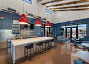 Thumbnail 4 of 35 - A modern kitchen with a long white island and bar stools.at Marketside Villas at Verrado, Buckeye, 85396
