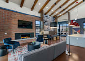 Thumbnail 5 of 35 - A modern living room with a brick fireplace and a grey sofa.at Marketside Villas at Verrado, Buckeye, AZ, 85396