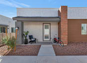 Thumbnail 9 of 35 - A modern house with a bicycle parked in front.at Marketside Villas at Verrado, Arizona