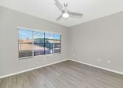 Thumbnail 14 of 37 - an empty living room with a large window and a ceiling fan