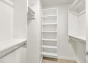 Thumbnail 15 of 37 - a closet in a white room with shelves and