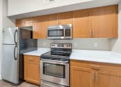 Thumbnail 18 of 37 - a kitchen with stainless steel appliances and wooden cabinets