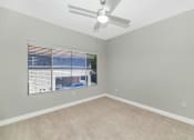 Thumbnail 23 of 37 - an empty bedroom with a large window and a ceiling fan