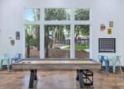 Thumbnail 10 of 36 - a pool table in a room with windows and a view of a park at Montage at Pecos Ranch Apartments, Chandler, 85286