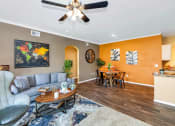 Thumbnail 13 of 36 - A living room with a grey chair and a wooden coffee table at Montage at Pecos Ranch Apartments, Chandler, AZ, 85286