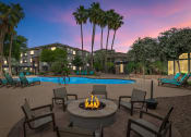 Thumbnail 1 of 36 - A fire pit sits in the middle of a patio at Montage at Pecos Ranch Apartments, Arizona, 85286