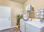 Thumbnail 20 of 36 - the washer and dryer in a laundry room with a white door at Montage at Pecos Ranch Apartments, Arizona, 85286