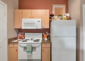 Thumbnail 22 of 36 - A kitchen with a white stove and a white refrigerator at Montage at Pecos Ranch Apartments, Chandler, 85286