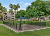 Thumbnail 30 of 36 - A black fence surrounds a green lawn in front of a building at Montage at Pecos Ranch Apartments, Chandler, 85286