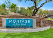Thumbnail 35 of 36 - A sign for Montage at Peccary Ranch Apartment Homes is displayed in front of a grassy area at Montage at Pecos Ranch Apartments, Chandler, AZ, 85286