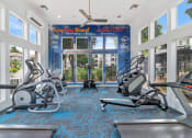 Thumbnail 5 of 36 - a gym with treadmills and weights in front of windows at Montage at Pecos Ranch Apartments, Chandler, Arizona
