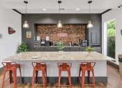Thumbnail 9 of 36 - A kitchen with a bar area and four stools at Montage at Pecos Ranch Apartments, Chandler, AZ