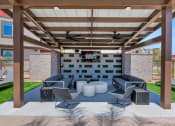 Thumbnail 25 of 76 - a covered patio with couches and chairs and a televisionat Weylyn Luxury Apartments, Laveen