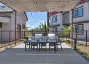 Thumbnail 26 of 76 - a patio with a dining table and chairs under a canopyat Weylyn Luxury Apartments, Laveen