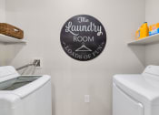 Thumbnail 45 of 76 - the laundry room has a washer and dryer and a sign on the wall at Weylyn Luxury Apartments, Laveen, Arizona