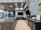 Thumbnail 23 of 51 - A modern kitchen with a marble countertop and wooden cabinets. at The Laurel Apartments, Chandler, 85286  