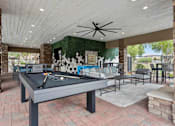 Thumbnail 36 of 51 - A pool table is in the middle of a room with a ceiling fan. at The Laurel Apartments, Arizona, 85286