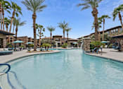 Thumbnail 34 of 51 - A swimming pool surrounded by palm trees and lounge chairs. at The Laurel Apartments, Chandler, 85286  