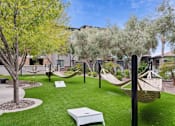 Thumbnail 44 of 51 - A backyard with a white hammock and a white bench. at The Laurel Apartments, Chandler Arizona  