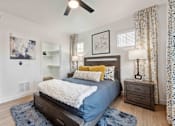 Thumbnail 6 of 51 - A bedroom with a bed, nightstand, and a ceiling fan. at The Laurel Apartments, Chandler, AZ 85286  
