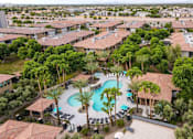 Thumbnail 49 of 51 - A large swimming pool surrounded by palm trees and lounge chairs in a residential area. at The Laurel Apartments, Chandler, AZ  