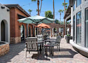 Thumbnail 20 of 40 - A patio with a table and chairs under an umbrella. at Lazo Apartment Homes, Arizona  