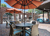 Thumbnail 21 of 40 - A patio with tables and chairs under umbrellas. at Lazo Apartment Homes, Arizona, 85225