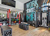 Thumbnail 19 of 40 - A gym with a variety of equipment including a squat rack, bench, and weights. at Lazo Apartment Homes, Arizona  