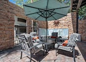 Thumbnail 22 of 40 - A patio with a table and chairs under an umbrella. at Lazo Apartment Homes, Chandler, AZ  