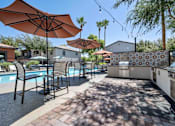 Thumbnail 32 of 40 - A poolside area with umbrellas and chairs. at Lazo Apartment Homes, Chandler, 85225  