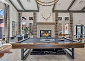 Thumbnail 5 of 40 - A pool table is in the middle of a room with a fireplace and a deer head mounted on the wall. at Lazo Apartment Homes, Chandler, AZ  