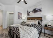 Thumbnail 9 of 40 - A bedroom with a bed, two lamps, and a painting on the wall. at Lazo Apartment Homes, Arizona  