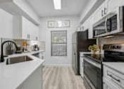 Thumbnail 8 of 40 - A modern kitchen with black appliances and white cabinets. at Lazo Apartment Homes, Chandler, AZ  