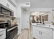 Thumbnail 3 of 40 - A kitchen with white cabinets and a black stove top oven. at Lazo Apartment Homes, Chandler, 85225  