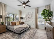 Thumbnail 10 of 40 - A bedroom with a bed, dresser, and ceiling fan. at Lazo Apartment Homes, Chandler  