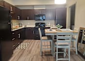 Thumbnail 6 of 14 - Modern kitchen with dining area and wood flooring at Pinon Lofts Apartments, Sedona, AZ
