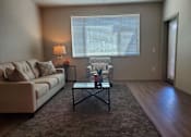 Thumbnail 7 of 14 - Living room with modern furniture and large window at Pinon Lofts Apartments, Sedona, 86336