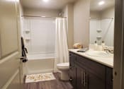 Thumbnail 8 of 14 - Modern bathroom with white countertop and dark cabinets at Pinon Lofts Apartments, Sedona, Arizona