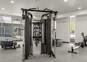 Thumbnail 10 of 26 - Fitness center with cable machine and rowing equipment at Lucero Apartments, Phoenix, 85051