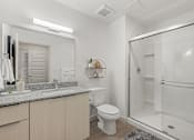 Thumbnail 21 of 26 - Bathroom with granite countertops and glass shower at Lucero Apartments, Arizona, 85051