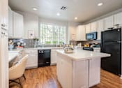 Thumbnail 4 of 42 - A kitchen with black appliances and white cabinets.at Palazzo Townhomes, Phoenix, AZ 85008  