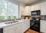 Thumbnail 1 of 42 - A kitchen with white cabinets and a black oven.at Palazzo Townhomes, Phoenix, AZ  