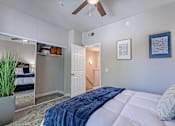 Thumbnail 18 of 42 - A bedroom with a bed, a ceiling fan, and a potted plant.at Palazzo Townhomes, Phoenix, 85008  