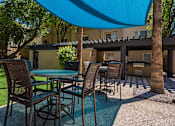 Thumbnail 38 of 42 - A patio with a table and chairs under a blue umbrella.at Palazzo Townhomes, Phoenix, 85008  