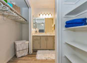 Thumbnail 11 of 34 - A bathroom with a white laundry basket and a white rug at Reflections at Red Mountain Apartments, Mesa, AZ