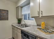 Thumbnail 7 of 34 - A kitchen with a sink, a window with blinds, and a chalkboard with drink names at Reflections at Red Mountain Apartments, Mesa