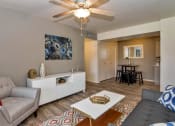 Thumbnail 5 of 34 - A living room with a grey couch, a white coffee table, and a ceiling fan. at Reflections at Red Mountain Apartments, Mesa 85213