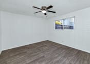 Thumbnail 11 of 26 - A room with a ceiling fan and a window with bars at The Phoenix Apartments on 6th Avenue, Phoenix, Arizona